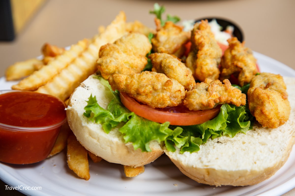 A fresh, hot, oyster po-boy sandwich with french fries
