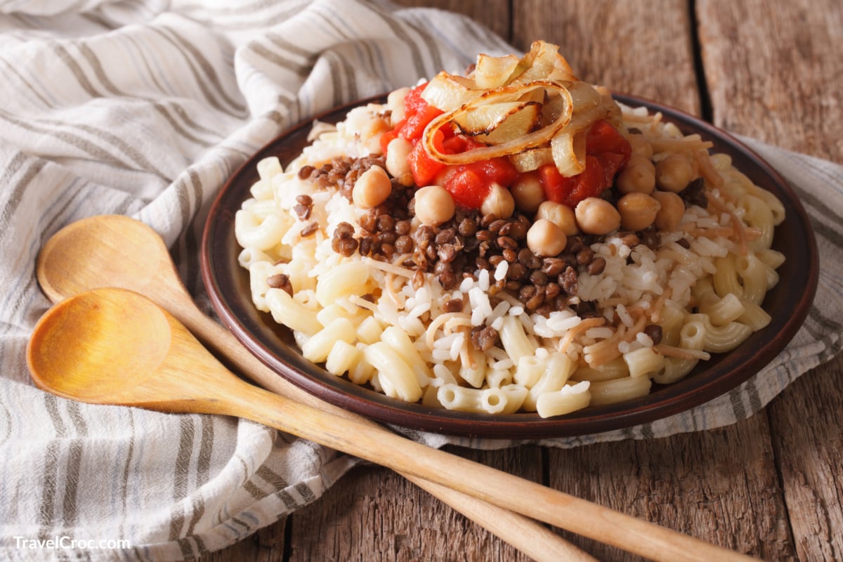 Arabic cuisine kushari of rice, pasta, chickpeas and lentils close up on a plate