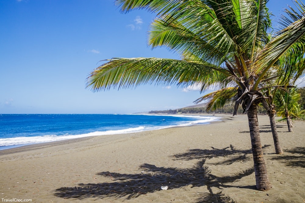 Etang-Sale beach on Reunion Island with its characteristic black sand and the waves of the Indian Ocean