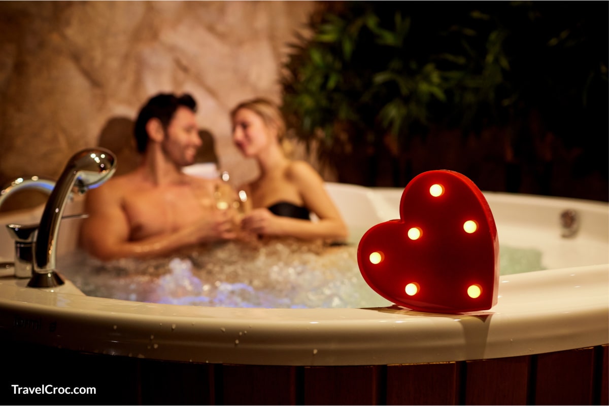 Couple enjoying romantic getaway in Indianapolis hotel with hot tub in room.
