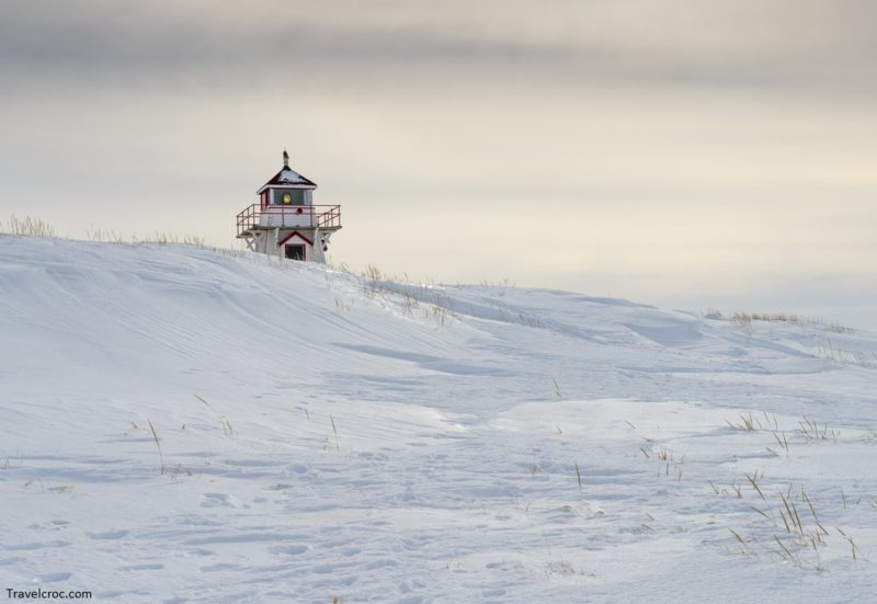 Covehead lighthouse in a snow covered sand dune mid winter.