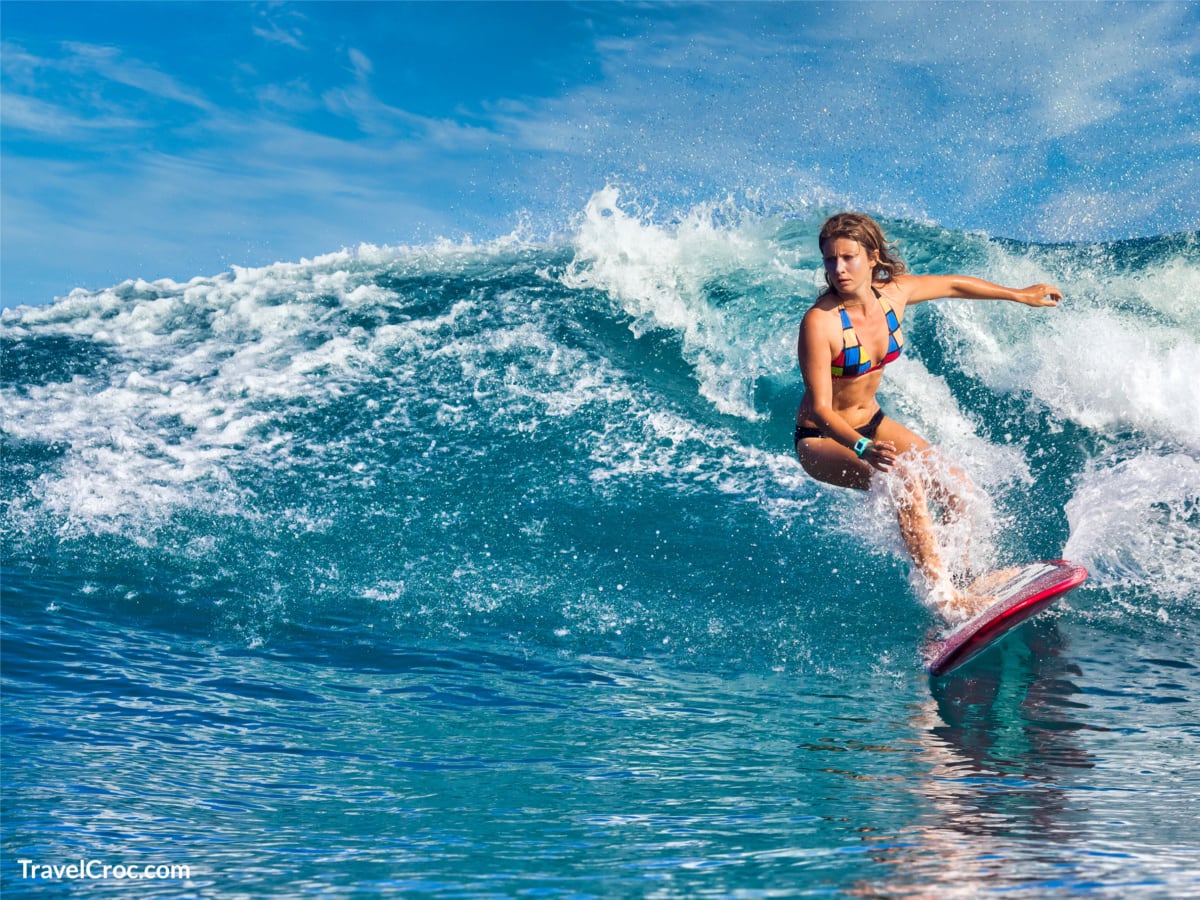 Female surfer catching a blue wave