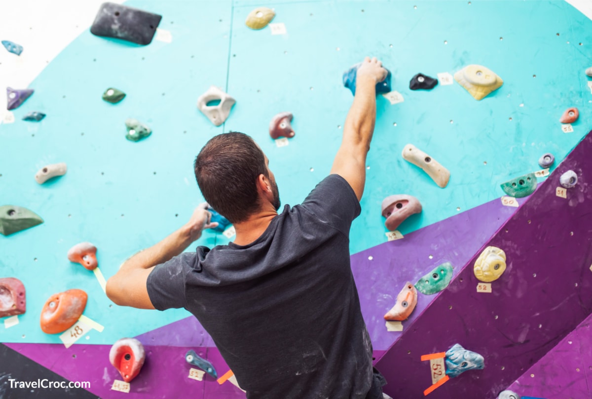 Man climbing high at indoor rock climbing center