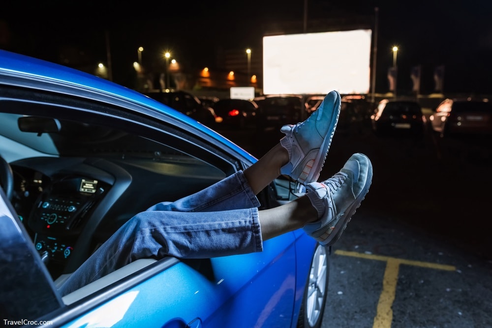 woman hanging her legs out of car window while watching a movie at drive in cinema - Romantic Things to do in Rocky Mount NC
