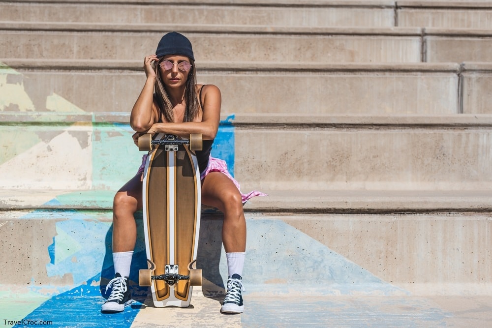 A Caucasian girl sits on some concrete benches after using a skateboard -Littleton Skatepark - Best skateparks in Colorado