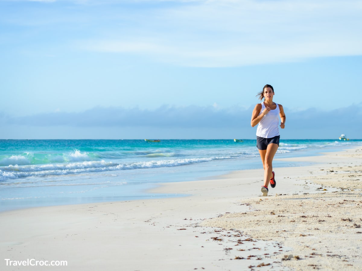 Woman jogging on beach during carribean holiday