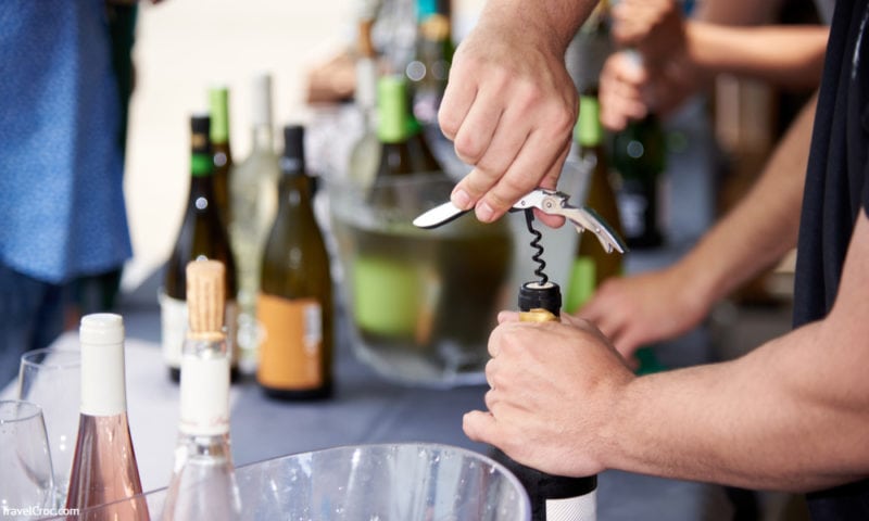 Prosser Washington Wineries Guide - man uncorking a bottle of wine with corkscrew
