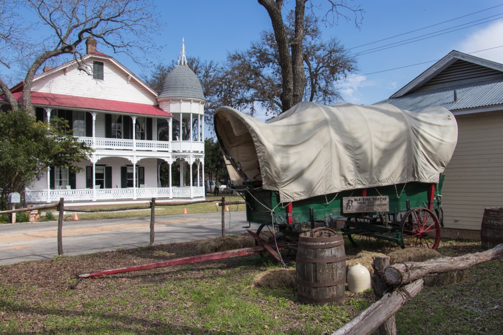 Covered wagon outside a historic building in Gruene, TX