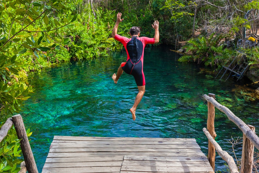 Man jumping into a cenote.